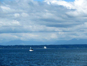 Boats sailing in sea against sky