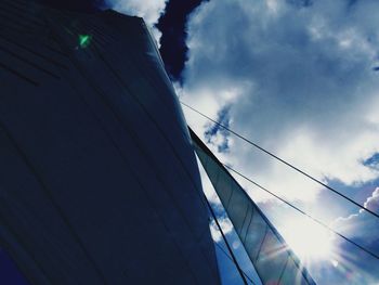 Low angle view of electricity pylon against blue sky