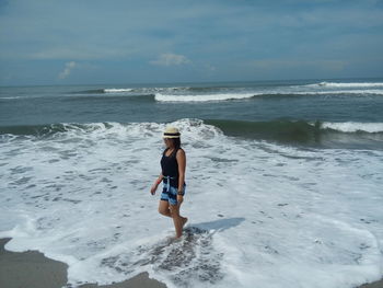 Full length of boy on beach against sky