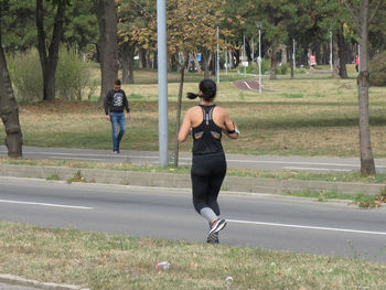 Full length rear view of man running on road