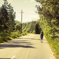 Rear view of woman walking on road