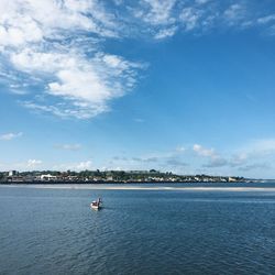 Lone boat in calm sea against blue sky