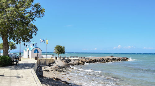 Church at sea shore against sky