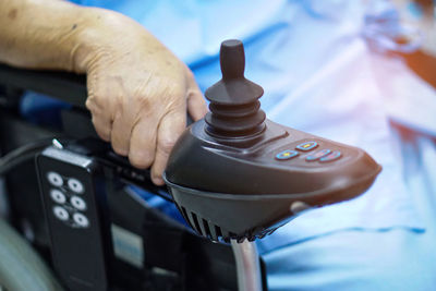 Midsection of male patient sitting on wheelchair