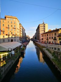 Canal amidst buildings against sky