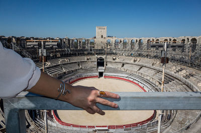 Midsection of man with arms outstretched against sky