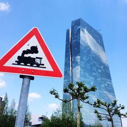 Low angle view of road sign against blue sky