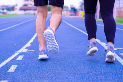 Low section of couples running on track