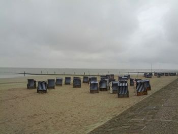 Scenic view of beach against cloudy sky