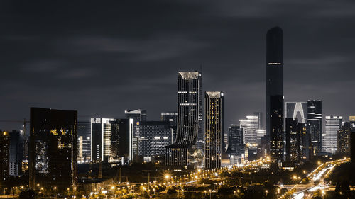 Illuminated buildings against sky at night