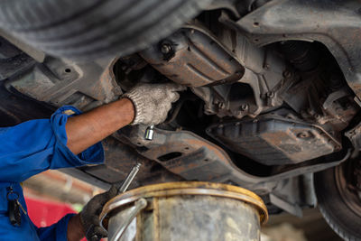 Midsection of man repairing car engine