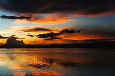 Scenic view of sea against dramatic sky during sunset