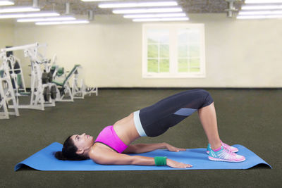 Mid adult woman doing yoga in gym