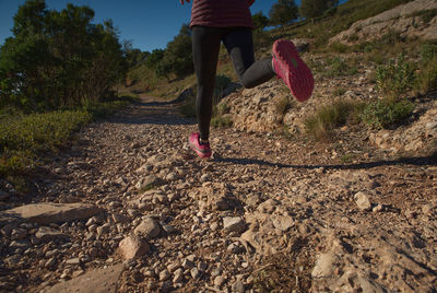 Shot from below of legs of sporty woman running through the mountains of catalonia, spain.