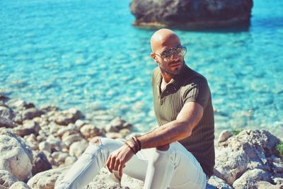 Man sitting on rocks at beach