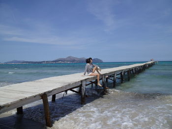 Rear view of woman looking at sea against sky