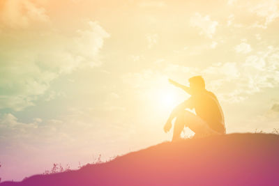 Silhouette man standing against sky during sunset