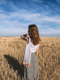 Woman standing on field against sky