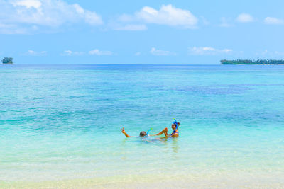 People enjoying in sea against sky