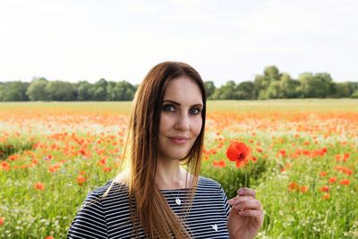 Portrait of beautiful young woman on field