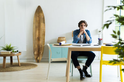 Full length of woman sitting on chair at table