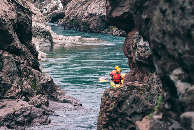 People on rock by sea