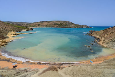 Scenic view of beach against clear blue sky