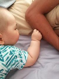 Low section of baby on bed