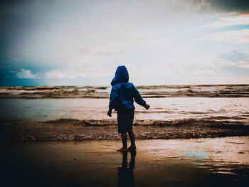 Full length rear view of man standing on beach