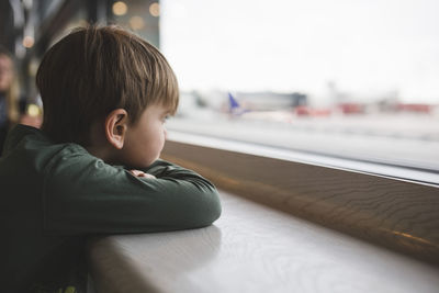 Boy looking through window of restaurant