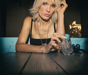 Portrait of woman with drinking glass on table