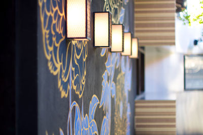 Close-up of lit wall lamps in a row