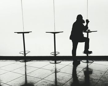 Silhouette woman standing against wall