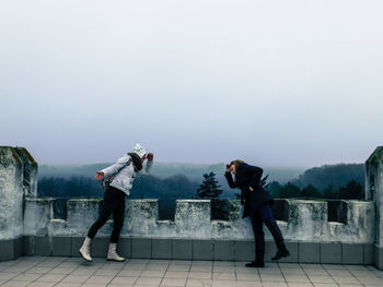 Rear view of women standing on temple against sky