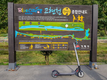 Bicycle sign on road by plants