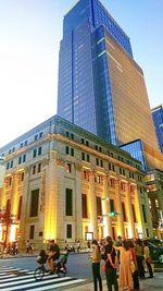 Low angle view of people on modern building against sky