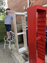 Full length of boy in house against building