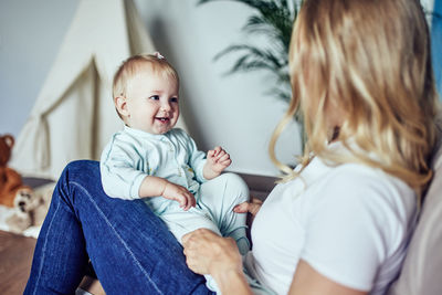 Mom and 1-year-old daughter spend time together at home.