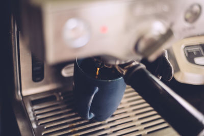 Close-up of fresh coffee pouring out of machine