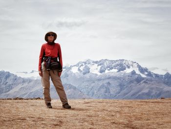 Full length of woman standing on land against mountain range