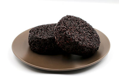 Close-up of chocolate cake in plate against white background