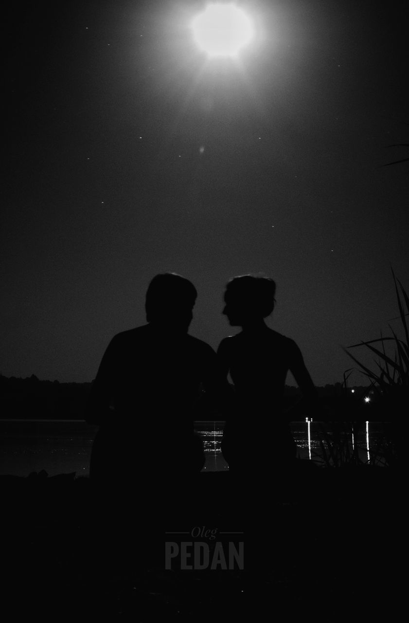 SILHOUETTE COUPLE AGAINST SKY AT NIGHT