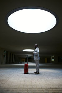 African american traveler with a red suitcase. person