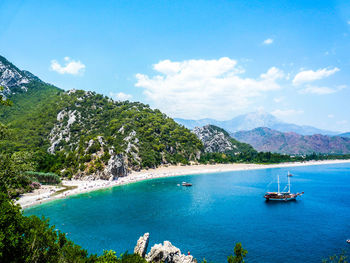 Boats in sea with mountains in background