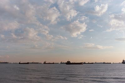 Boats sailing on sea against sky during sunset