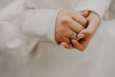 Female hands nervously folded into each other, unrecognizable person, selective focus