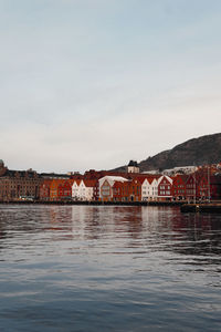 Scenic view of lake by buildings against sky