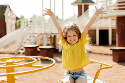 A charming little girl is walking in the park, swinging on a swing. happy childhood, playtime