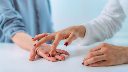 Examining the hand of a senior patient with carpal tunnel syndrome