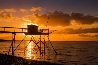 Fishing hut on stilts at sunset by the atlantic ocean in charente maritime in france